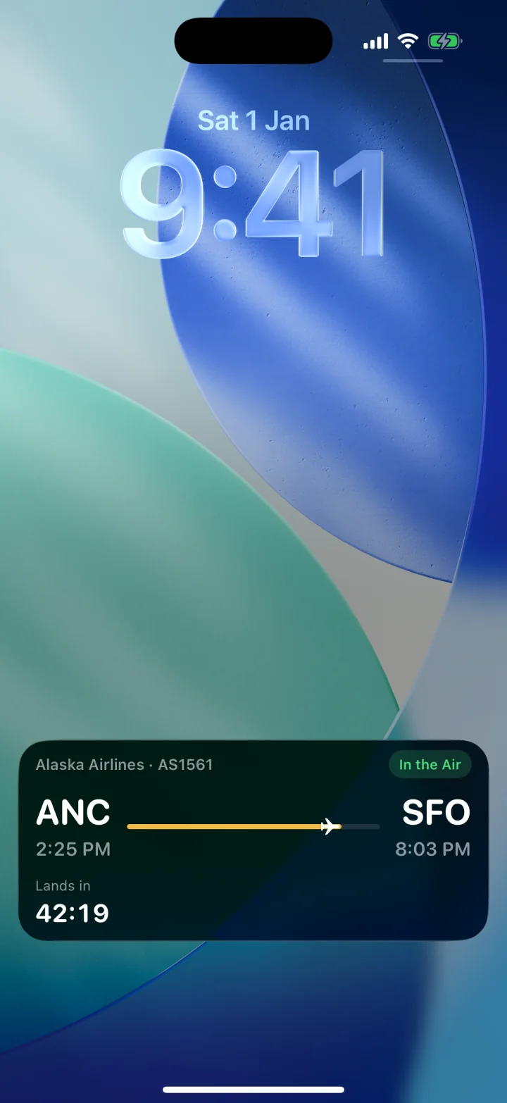 iPhone lock screen showing a live Alaska Airlines flight from Anchorage to San Francisco, in the air, landing in 42 minutes.